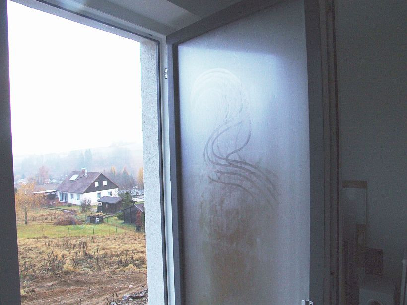 Foto eines offenen Fensters, bei dem sich Kondensat auf der Außenseite der Scheibe bildet