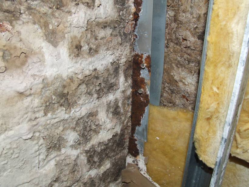 Schimmel auf einer Natursteinwand, verrostete Metallteile wegen Belüftungsmöglichkeit Schimmel auf einer Natursteinwand, verrostete Metallteile wegen Belüftungsmöglichkeit