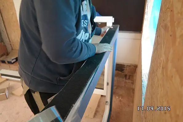 Verlegen von Quellband auf dem äußeren Fensterrahmen