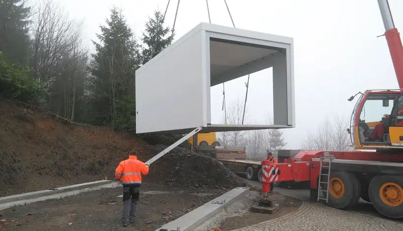 Eine freistehende Fertigteil-Garage wird abgeladen und aufgestellt