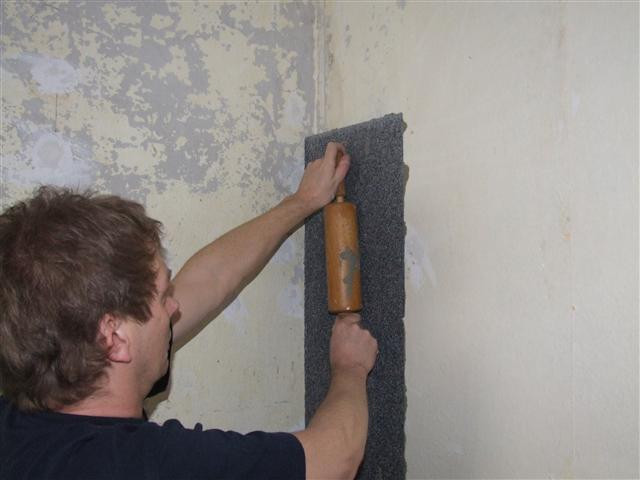 Ein erster Dämmkeil wird in die Außenwandecke geklebt